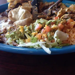 Steak Burrito with cheese sauce. Served with guacamole and rice and beans.