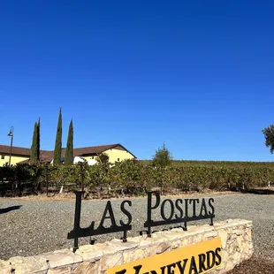 a sign in front of a vineyard