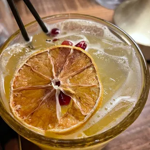 Mixed drink on cocktail menu with passionfruit juice, tequila, and pomegranate perils