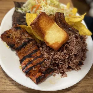Plato Nica-Pork, carne asada, gallo pinto, maduro, platano, y ensalada.