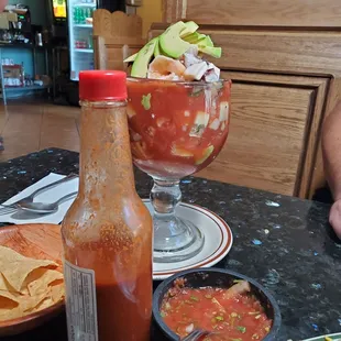 a glass of salsa and a bowl of tortillas