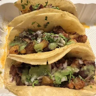 three tacos in a styrofoam container