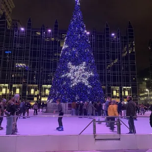 people skating around a lighted christmas tree