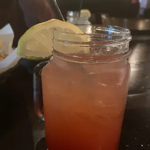 a drink in a mason jar with a lime slice