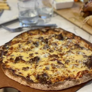 Cheesesteak pizza with hot peppers on the side