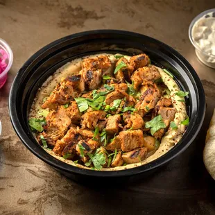 a bowl of chicken and pita