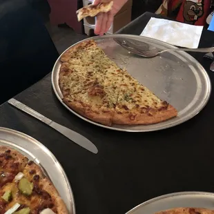 a person taking a slice of pizza