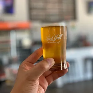 a hand holding a glass of beer