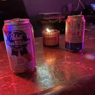 two cans of beer on a bar