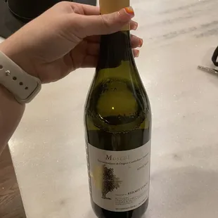 a hand holding a bottle of wine