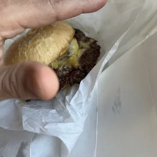 a hand holding a hamburger