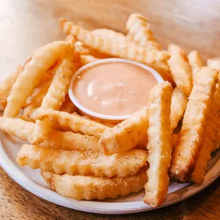 a plate of french fries with dipping sauce