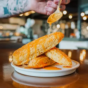 a person dipping a piece of bread into a bowl