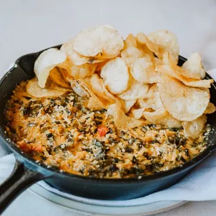 a skillet of food with chips