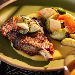 Jerk Pork Chop with charred brussel sprouts, butternut squash rundown, carrots, roasted turnips, tomato &amp; cucumber chow, marcona almonds.