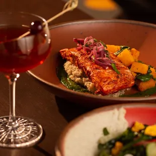 Enjoy our flavorful Harissa Roasted Salmon served with fonio, butternut cooked in awaze, ta- malice, kale, sauce mojito.