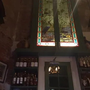 Cathedral ceilings and pretty stained glass cabinet against exposed brick walls - lovely old world feel.