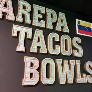 a sign that says arepa tacos bowls