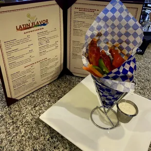 a basket of chicken wings with dipping sauce