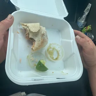 a half eaten sandwich in a styrofoam container
