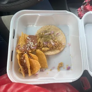 a taco and chips in a styrofoam container