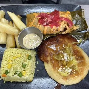 Catracho Combo $15.75 one Honduran tamal topped with chipotle and red encurtido, 1 pupusa, side of rice and fried yuca