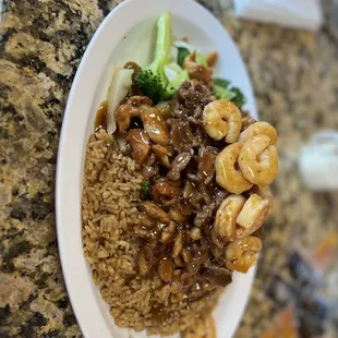 a plate of rice with shrimp and broccoli