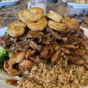 a plate of rice with shrimp and broccoli