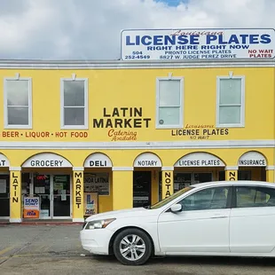 a white car parked in front of a yellow building