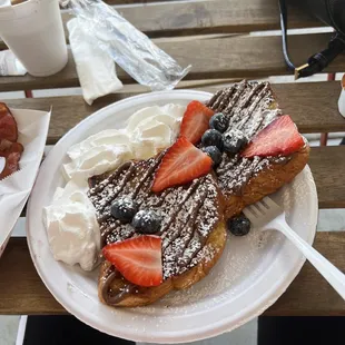 Brioche French toast with Nutella and fruits and a side of a cream