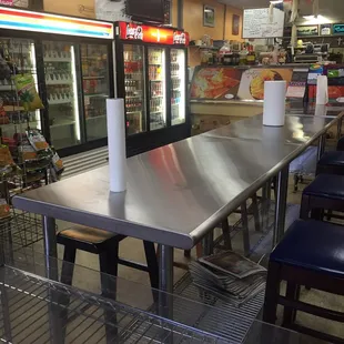 Dining area in foreground, hot food/deli beyond coolers.