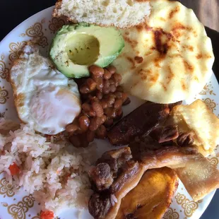 I arranged my Bandeja Paisa on a plate. At the top of the picture is a chunk of sweet bread sprinkled w/ sesame seeds.