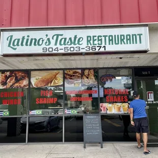 a man standing in front of a restaurant
