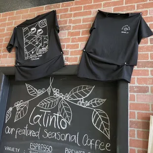 a chalkboard with t - shirts on it