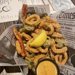 a basket of fried onion rings and dipping sauce