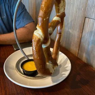 a pretzel on a plate with dipping sauce