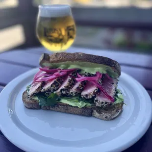 Ahi Tuna Sandwich with pea jalapeño remoulade, pickled red onion, ginger vinaigrette and fine herbs on sourdough rye