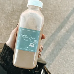 a person holding a bottle of coffee