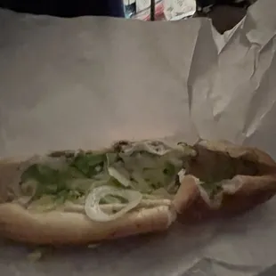 a hot dog with onions and lettuce
