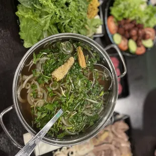 a pot of soup with noodles and vegetables