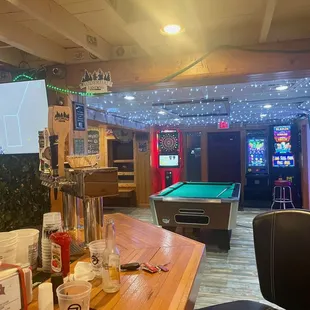 Seated at the end of the bar looking into the pool table room