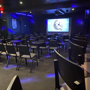 a conference room with chairs and a projector screen