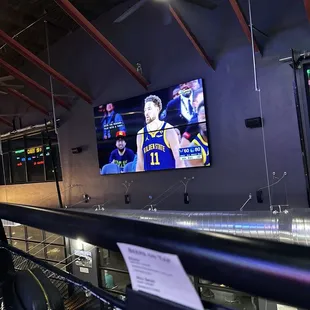 a man watching a basketball game on a big screen
