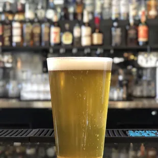 a glass of beer on a bar