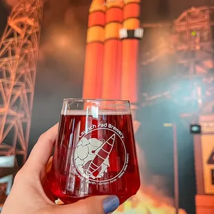 a hand holding a glass of beer