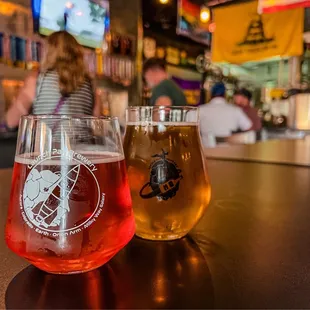 two glasses of beer on a bar