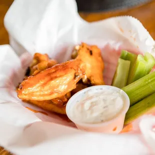 a basket of chicken wings and celery