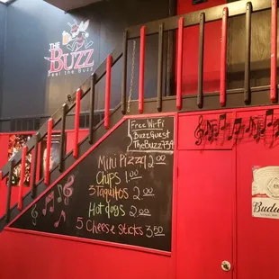 a red wall with a blackboard menu on it