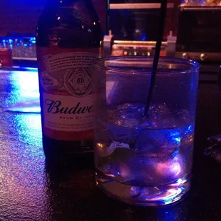 a bottle of budlow and a glass of water