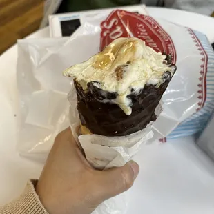 a hand holding an ice cream cone